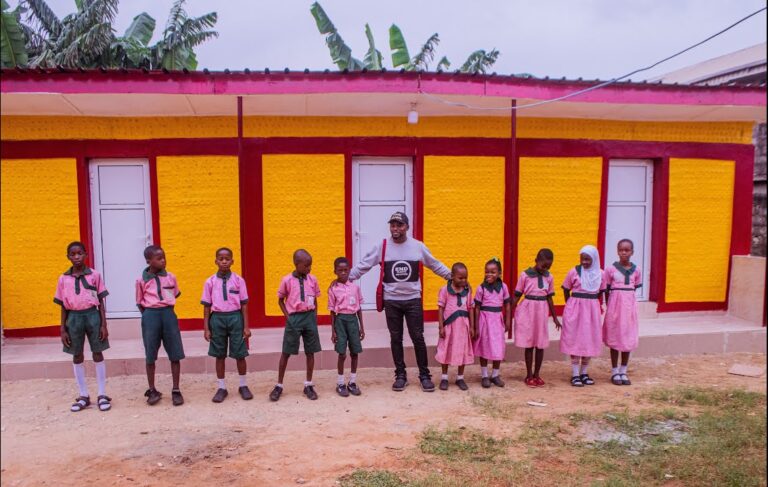 Executive Director of International Climate Change Development Initiative (ICCDI), Olumide Idowu with pupils of the school on launching the plastic bottle toilet project at Ilasamaja Primary School in Lagos